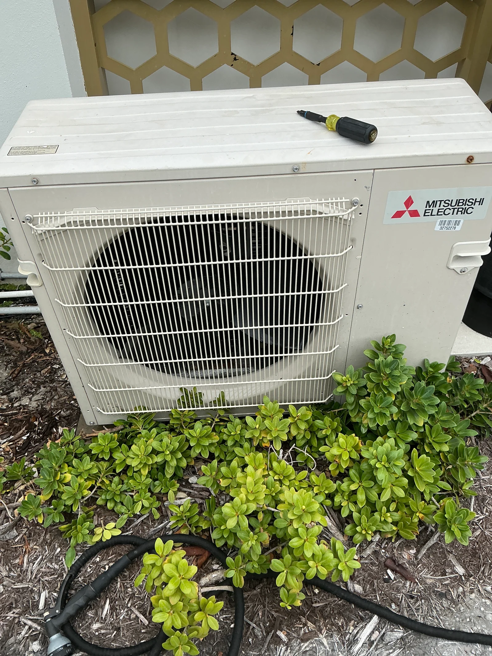 Outdoor ductless AC unit beside landscaping