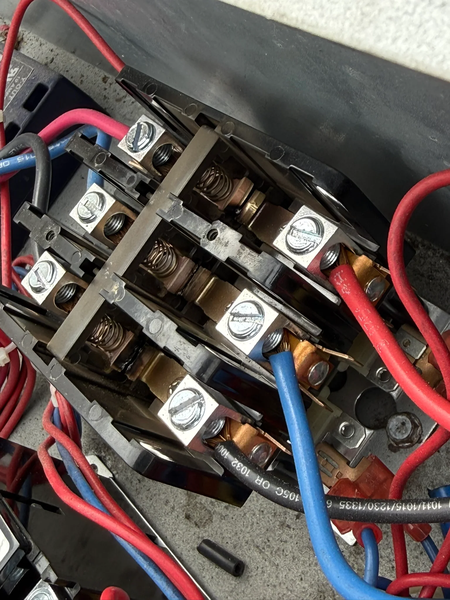 Close-up of contactor terminals and wiring inside AC equipment